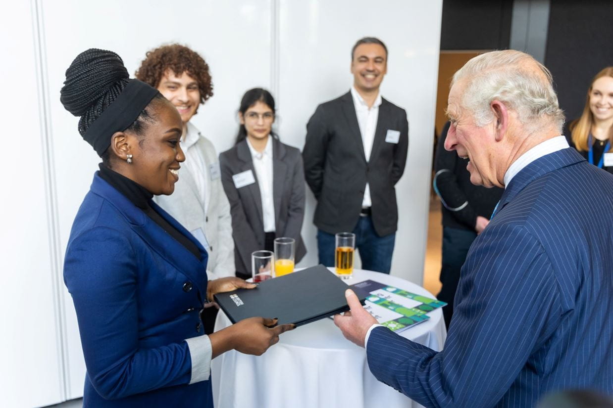 Group of students presenting a folder to HRH Prince Charles)